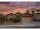 Desert home at sunset features a tan exterior, attached garage, and drought-resistant landscaping at 10513 Shanna Trellis Ave, Las Vegas, NV 89144