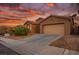 Desert home at sunset features a tan exterior, attached garage, and drought-resistant landscaping at 10513 Shanna Trellis Ave, Las Vegas, NV 89144