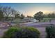 Tranquil view of a golf course with lush greens, mature trees, and a winding road, creating a serene atmosphere at 10513 Shanna Trellis Ave, Las Vegas, NV 89144