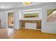 Bright living room with hardwood floors, large windows, and a stone accent wall below the window at 10513 Shanna Trellis Ave, Las Vegas, NV 89144