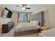 Bedroom features a large gray headboard, modern ceiling fan, and dresser with TV at 10973 Sardinia Sands Dr, Las Vegas, NV 89141