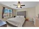 Bedroom features a large gray headboard, modern ceiling fan, and large window at 10973 Sardinia Sands Dr, Las Vegas, NV 89141