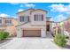 Inviting two-story home boasts a spacious garage, neutral-toned facade, manicured greenery, and an accessible front entrance at 10973 Sardinia Sands Dr, Las Vegas, NV 89141
