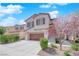 Attractive two-story house with attached garage, natural hues, manicured shrubs, and a welcoming front entry with steps at 10973 Sardinia Sands Dr, Las Vegas, NV 89141