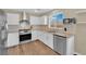 Well lit kitchen featuring stainless steel appliances and white cabinets, and wood-look flooring at 10973 Sardinia Sands Dr, Las Vegas, NV 89141