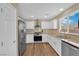 Updated kitchen features granite countertops, stainless steel appliances, and white cabinets at 10973 Sardinia Sands Dr, Las Vegas, NV 89141