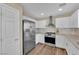 This kitchen features stainless steel appliances, white cabinets, granite countertops and wood-look flooring at 10973 Sardinia Sands Dr, Las Vegas, NV 89141