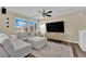 Comfortable living room with a large sectional sofa, media center, ceiling fan and bright natural lighting at 10973 Sardinia Sands Dr, Las Vegas, NV 89141