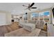 Open-concept living room featuring hardwood floors, a comfortable sectional sofa, and access to the kitchen at 10973 Sardinia Sands Dr, Las Vegas, NV 89141