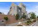 Attractive three-story townhome showcasing a modern design with a private balcony and well-kept landscaping at 11325 Gravitation Dr, Las Vegas, NV 89135
