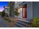 A modern front entrance featuring a red door, gray siding and a landscaped walkway at 11325 Gravitation Dr, Las Vegas, NV 89135