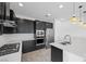Modern kitchen with stainless steel appliances, dark cabinets, and bright white countertops at 11325 Gravitation Dr, Las Vegas, NV 89135