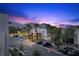 Scenic street view of modern homes, palm trees, and mountain backdrop at twilight at 11325 Gravitation Dr, Las Vegas, NV 89135