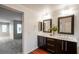 Modern bathroom features a double vanity with dark cabinets and wood-look floors at 11334 Colinward Ave, Las Vegas, NV 89135