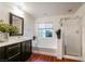 Bright bathroom featuring dual sinks, a tub, and dark wood cabinets at 11334 Colinward Ave, Las Vegas, NV 89135