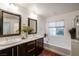 Modern bathroom with dual sinks, tub, and dark wood cabinets at 11334 Colinward Ave, Las Vegas, NV 89135
