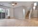 Bright living room with sliding doors to patio, ceiling fan, stairs, and wood-look flooring at 11334 Colinward Ave, Las Vegas, NV 89135