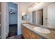 Bright bathroom featuring a double sink vanity with tile countertop and a large mirror with vanity lighting at 1342 Calle Calma, Henderson, NV 89012