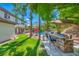 The backyard boasts a barbecue counter, luscious lawn, and a dining area next to the pool at 1409 Chambolle Ct, Las Vegas, NV 89144
