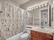 Bright bathroom featuring a shower over tub, cherry vanity and white sink at 1409 Chambolle Ct, Las Vegas, NV 89144