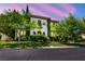 Elegant two-story home featuring lush landscaping, arched entryways, and a private balcony overlooking the front yard at 1409 Chambolle Ct, Las Vegas, NV 89144