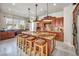 Well-lit kitchen with a large center island, granite countertops, modern lighting, and rustic wooden stools at 1409 Chambolle Ct, Las Vegas, NV 89144