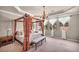 Well-lit primary bedroom featuring a four-poster bed, decorative curtains, and a comfortable sitting area at 1409 Chambolle Ct, Las Vegas, NV 89144
