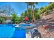 The backyard boasts a pool with a spa, lounge seating, and mature landscaping at 1409 Chambolle Ct, Las Vegas, NV 89144