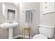 Cozy half bath featuring a pedestal sink, round mirror, and a white toilet at 1922 Pyle, Las Vegas, NV 89183