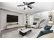 Bright living room features a ceiling fan, television, marble table and a staircase in a naturally lit open floorplan at 1922 Pyle, Las Vegas, NV 89183