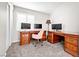 Bright office space featuring matching wooden desks, multiple monitors, and soft carpet at 1922 Pyle, Las Vegas, NV 89183