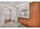 Bright bathroom featuring wood cabinetry, sleek countertops, and an adjacent walk-in closet at 200 W Sahara Ave # 2404, Las Vegas, NV 89102