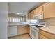 This kitchen features wooden cabinets, white appliances, light countertops, and a stainless steel sink at 2007 High Mesa Dr, Henderson, NV 89012