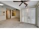 Spacious living room with neutral carpet, ceiling fan and sliding glass doors with shutter coverings at 2007 High Mesa Dr, Henderson, NV 89012