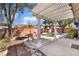 Relaxing backyard featuring a shaded patio area with pergola, a table, and a jacuzzi at 208 Lynbrook St, Henderson, NV 89012