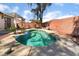 Inviting backyard with a sparkling jacuzzi, patio furniture, and desert-style landscaping at 208 Lynbrook St, Henderson, NV 89012