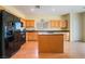 Kitchen featuring an island, wood cabinets, granite counters, and modern black appliances at 208 Lynbrook St, Henderson, NV 89012
