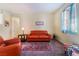 Cozy living room with warm-toned walls, a patterned rug, and a comfortable leather sofa at 208 Lynbrook St, Henderson, NV 89012
