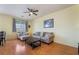 Bright living room featuring wood floors, a comfortable sofa, and large windows at 208 Lynbrook St, Henderson, NV 89012