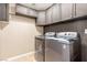 Convenient laundry room equipped with a washer, dryer and ample cabinet space at 209 Eucalyptus Ln, Mesquite, NV 89027