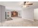 Spacious living room with neutral carpet, a ceiling fan with lighting, and a wooden entertainment center at 209 Eucalyptus Ln, Mesquite, NV 89027