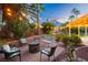 Cozy backyard with stone patio, outdoor seating, and a charming fire pit at 2401 Rice Flower Cir, Las Vegas, NV 89134