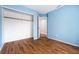 Blue bedroom with wood floors featuring a walk-in closet at 2401 Rice Flower Cir, Las Vegas, NV 89134