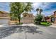Charming two-story home with a well-manicured lawn, mature trees, and front-facing garage at 2401 Rice Flower Cir, Las Vegas, NV 89134