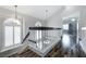 Upstairs hallway featuring wood-look floors, white railing, and a modern chandelier at 2401 Rice Flower Cir, Las Vegas, NV 89134