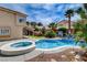 Private backyard oasis with a sparkling pool, spa, lush landscaping, and comfortable seating at 2401 Rice Flower Cir, Las Vegas, NV 89134