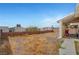 Unlandscaped backyard with gravel, brick wall, and covered patio at 2435 Paddock Ln, Las Vegas, NV 89156