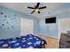 A bedroom with a blue-themed design, ceiling fan, and TV at 2435 Paddock Ln, Las Vegas, NV 89156