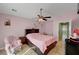 Bright bedroom with pink walls, tile floors, ceiling fan, and cute decor at 2435 Paddock Ln, Las Vegas, NV 89156