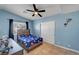 Bedroom with blue walls, ceiling fan, and tiled floors at 2435 Paddock Ln, Las Vegas, NV 89156